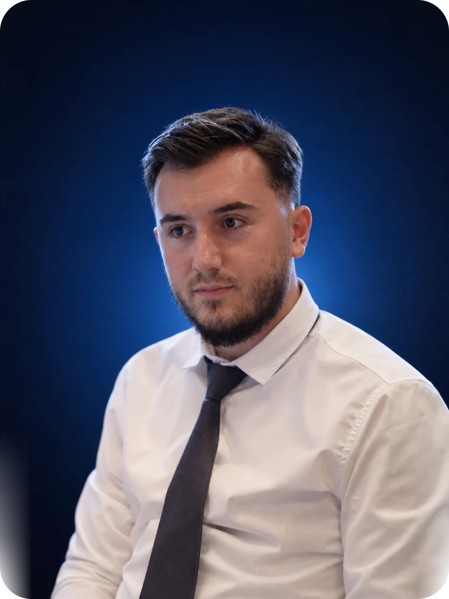 Portrait of Kreshnik Zabërgja, MEAN stack software developer, wearing a white shirt and dark tie